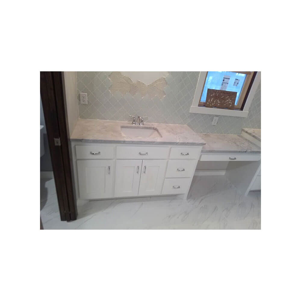 A gray countertop with a white wood cabinet