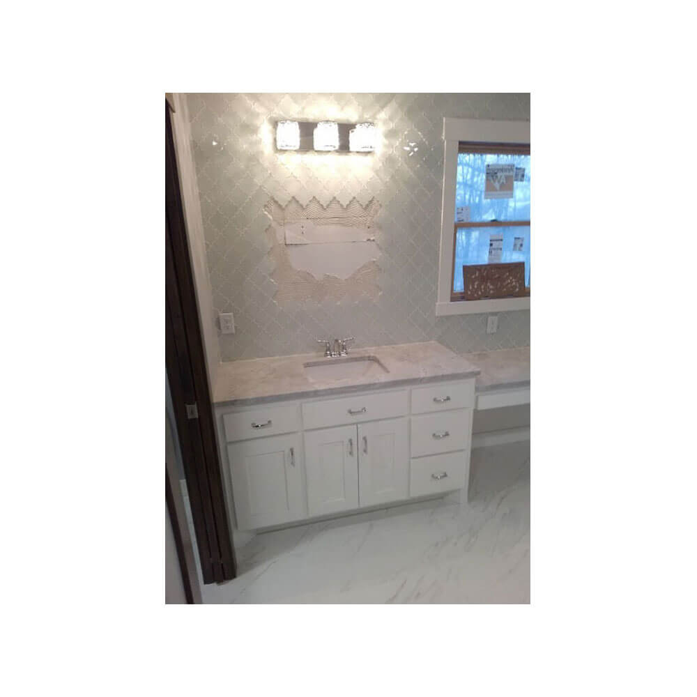 A sink in a bathroom with a gray granite counter top