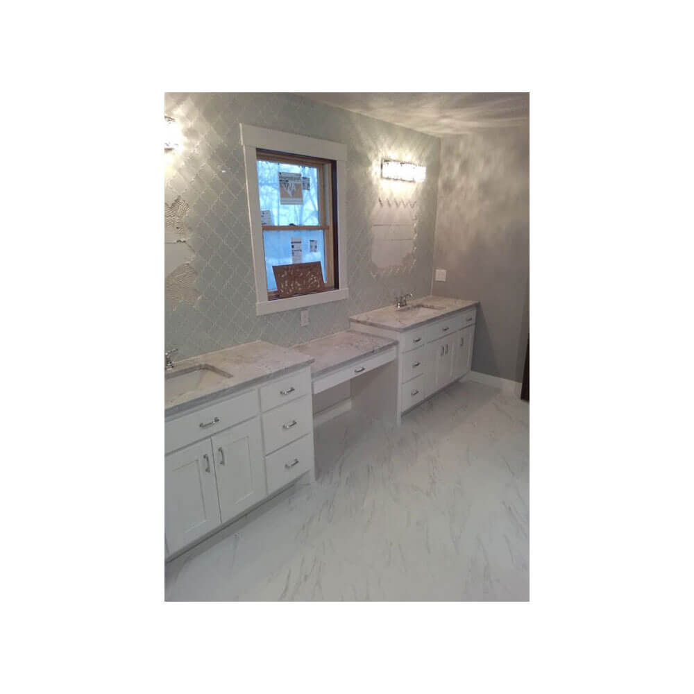 A bathroom with two sinks and a light gray counter top