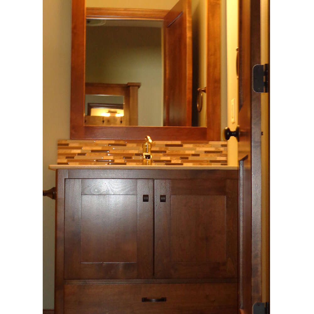 Dark wood bathroom sink with brick backsplash