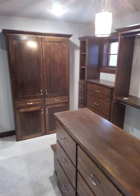 A light grey room with dark wood closet units