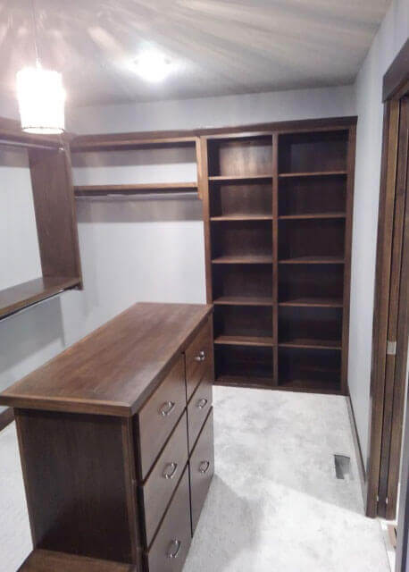 A gray room with dark, wooden shelving units