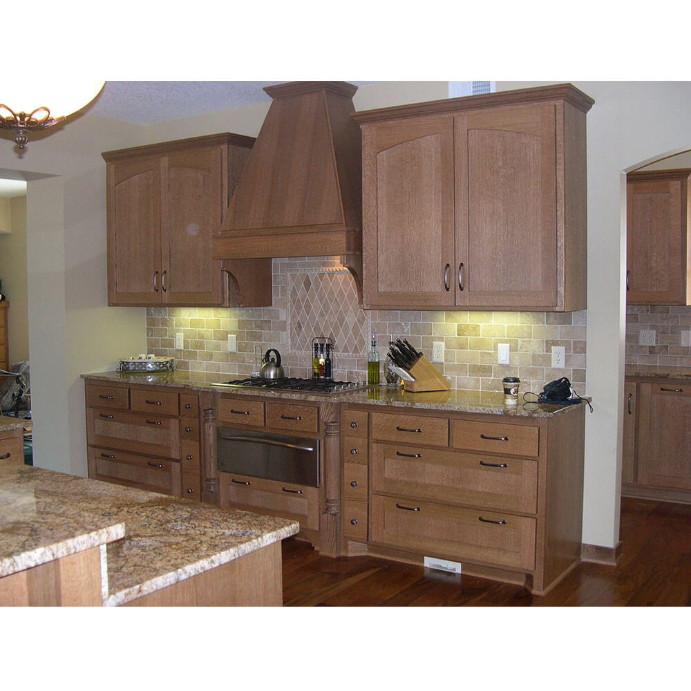 A kitchen with granite counters and solid, wooden cabinets