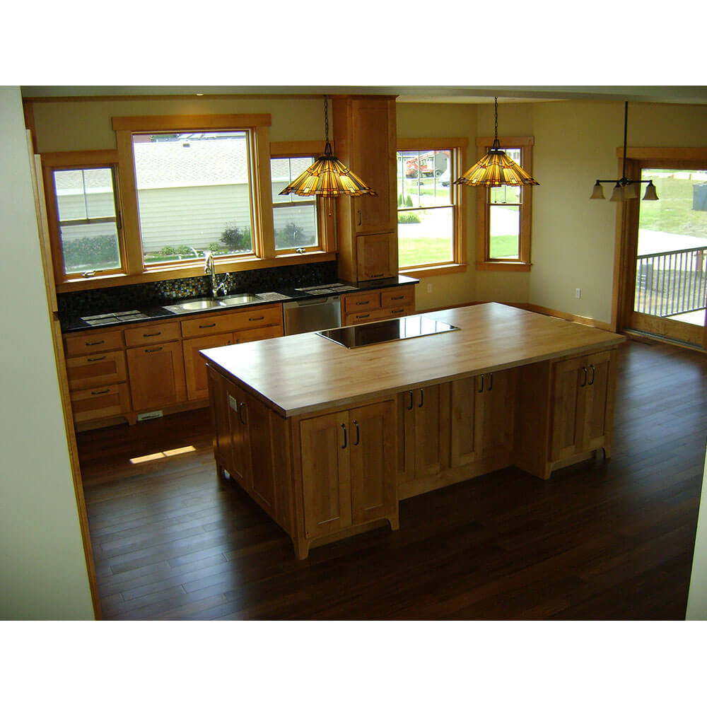 A kitchen with a large island and hardwood floors