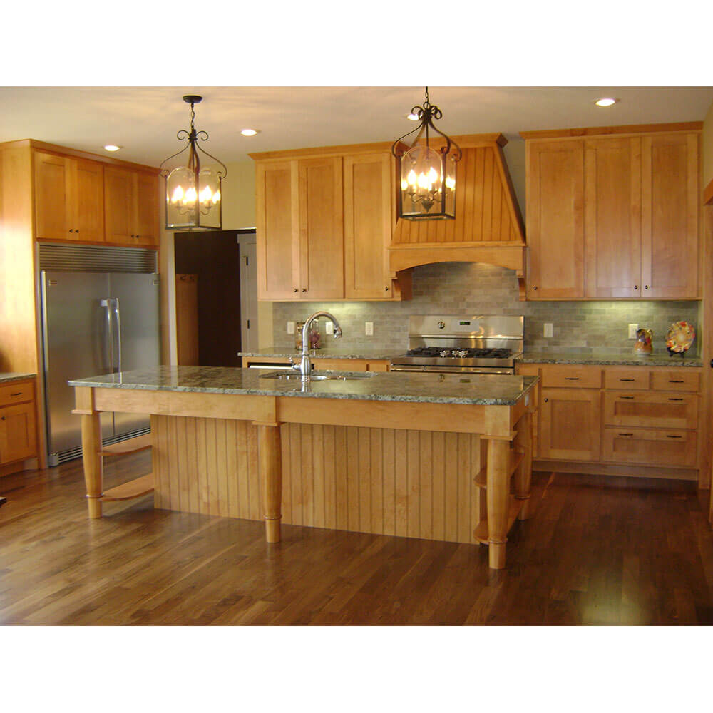 A full kitchen with wood cabinets, an island, and hardwood floors
