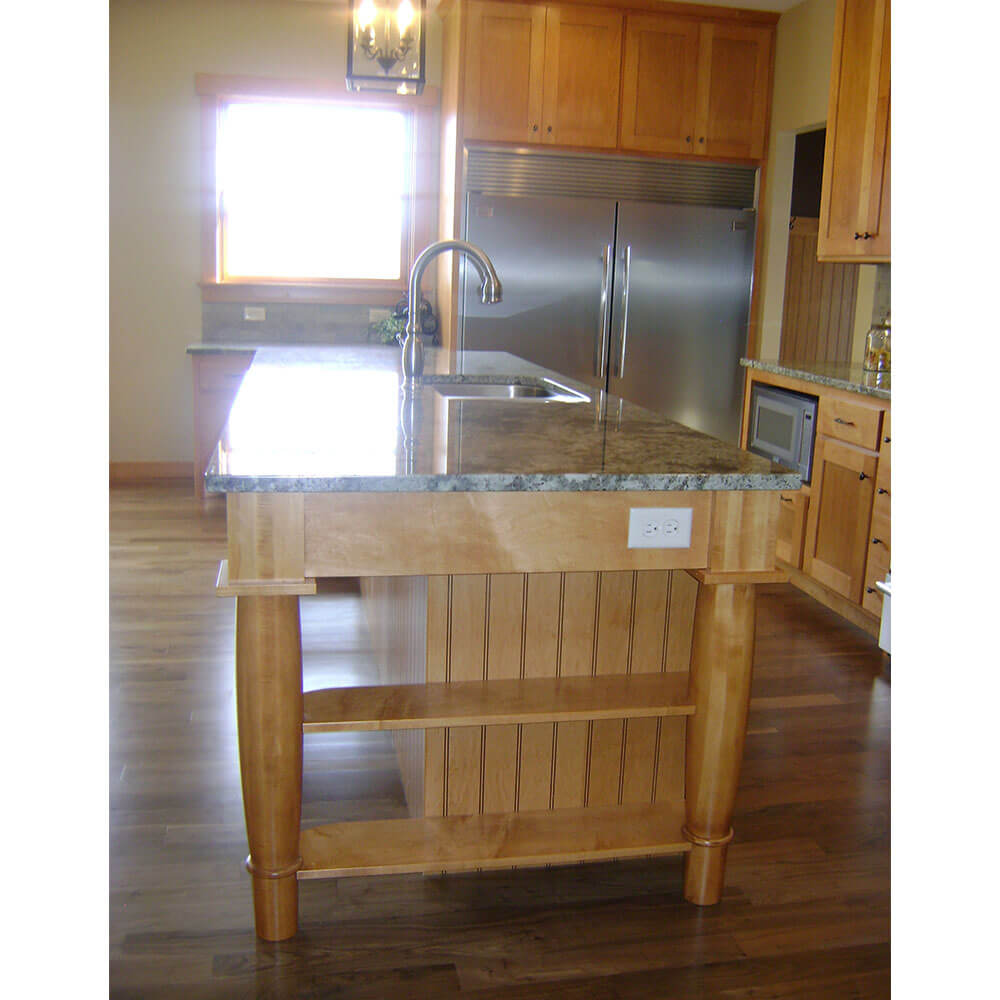 A kitchen island with a grey granite top